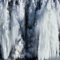 Gefrorener Wasserfall mit einer Wolke aus Diamantstaub - ein herrliches Phänomen des Winterlachses